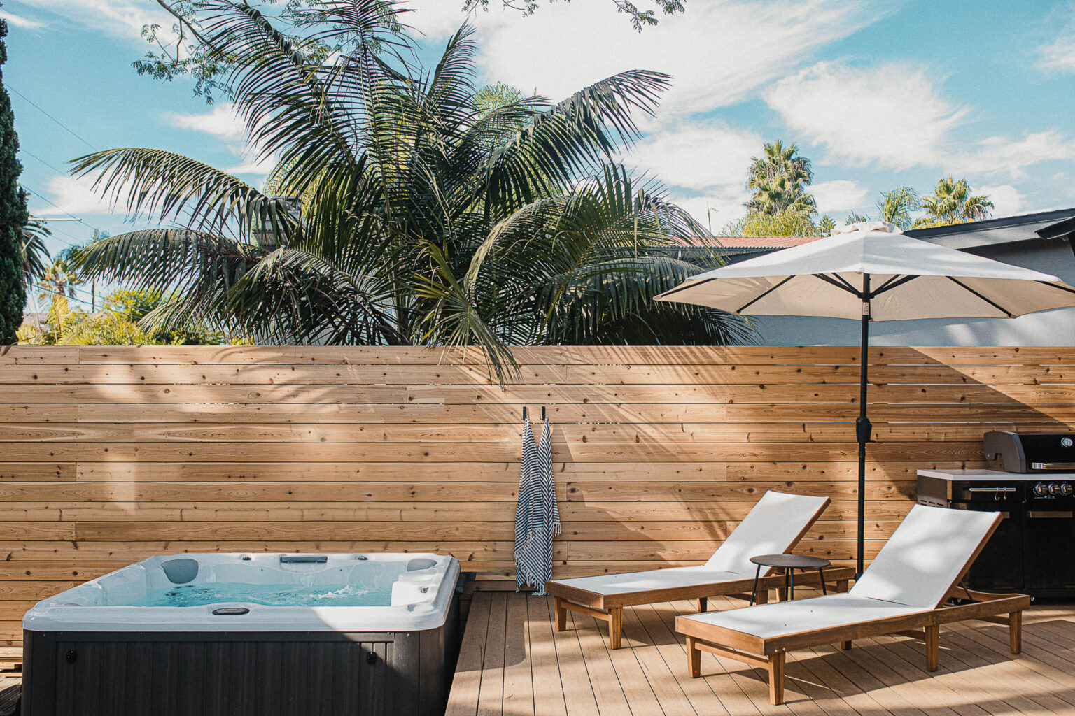 The hot tub and lounge chairs on the back deck