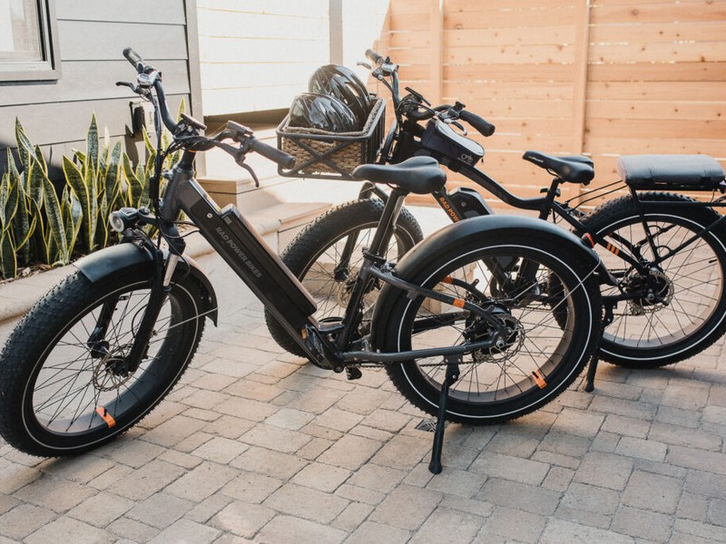 Two RAD e-bikes parked by the side gate